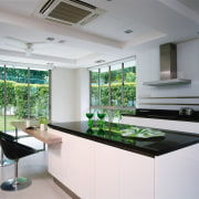 A view of the kitchen featuring white cabinetry, countertop, glass, interior design, kitchen, real estate, gray