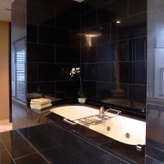 A view of the bathroom featuring dual recessed architecture, bathroom, ceiling, countertop, floor, flooring, glass, interior design, room, tile, black