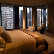 A view of this penthouse master bedroom featuring bedroom, ceiling, curtain, estate, floor, flooring, interior design, living room, property, real estate, room, suite, window, window blind, window covering, window treatment, wood, brown