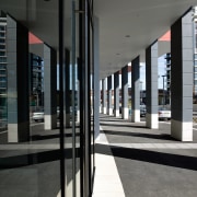 A view of this builidng corridor featuring  architecture, building, glass, metropolitan area, structure, window, black, gray