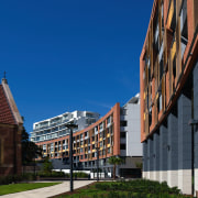 An exterior view of this multi storey apartment architecture, building, city, daytime, facade, house, metropolis, metropolitan area, mixed use, neighbourhood, residential area, sky, town, urban area, blue, black