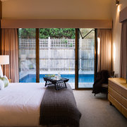 A view of this bedroom featuring carpet flooring, bedroom, ceiling, hotel, interior design, real estate, room, suite, window, window covering, window treatment, brown