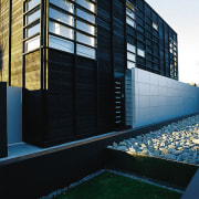 An exterior view of this contemporary home designed apartment, architecture, building, commercial building, condominium, corporate headquarters, facade, headquarters, home, house, reflection, residential area, window, black