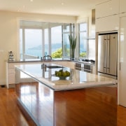 The intention was to design a kitchen that cabinetry, ceiling, countertop, floor, flooring, hardwood, interior design, kitchen, laminate flooring, living room, real estate, room, table, window, wood, wood flooring, orange, brown