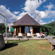 An exterior view of this coastal piha home cloud, cottage, estate, home, house, leisure, plant, property, real estate, sky, tree, villa, gray