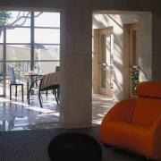 An interior view of the living areas featuring architecture, chair, door, floor, flooring, furniture, home, house, interior design, living room, table, window, black