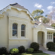 An exterior view of this renovated heritage home building, classical architecture, cottage, elevation, estate, facade, historic house, home, house, landscaping, mansion, official residence, property, real estate, residential area, roof, siding, structure, villa, window, gray