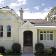 An exterior view of this renovated heritage home building, classical architecture, column, cottage, elevation, estate, facade, historic house, home, house, manor house, mansion, official residence, property, real estate, residential area, roof, siding, structure, window, gray