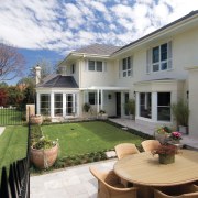 An exterior view of this renovated heritage home backyard, cottage, courtyard, estate, home, house, outdoor structure, property, real estate, residential area, siding, window, yard, gray