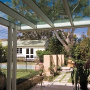 An exterior view of this renovated heritage home architecture, backyard, courtyard, estate, home, house, outdoor structure, patio, plant, porch, real estate, residential area, roof, structure, tree, walkway, black