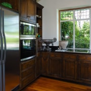 A view of this kitchen feautring solida aged countertop, home, house, kitchen, real estate, room, window, wood, black