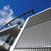 A view of this Apartment block featuring Louvres angle, architecture, building, commercial building, corporate headquarters, daylighting, daytime, elevation, facade, headquarters, house, line, roof, sky, structure, window, gray, blue