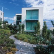 An exterior view of this clifftop house designed architecture, arecales, building, condominium, facade, home, house, real estate, residential area, sky