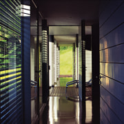 A view of the hallway featuring polished recycled architecture, door, glass, house, interior design, window, black, blue