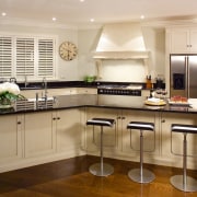 A view of this traditional kitchen featuring antique cabinetry, countertop, cuisine classique, floor, flooring, interior design, kitchen, room, wood flooring, orange, brown