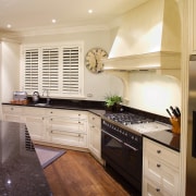 A view of this traditional kitchen featuring antique cabinetry, countertop, cuisine classique, floor, flooring, hardwood, home, interior design, kitchen, real estate, room, wood, wood flooring, orange