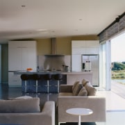 An interior view of the living area featuring architecture, ceiling, house, interior design, living room, real estate, table, gray