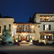 This spanish-style residence was transformed by the Landry building, estate, evening, facade, home, house, landscape lighting, lighting, mansion, mixed use, night, property, real estate, window, blue, black