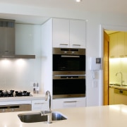 A view of this kitchen apartment featuring white cabinetry, countertop, cuisine classique, interior design, kitchen, room, gray