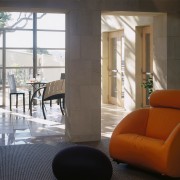 An interior view of the living areas featuring architecture, chair, door, floor, flooring, furniture, interior design, living room, table, window, brown
