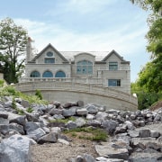 For more than 20 years, Tara Designer Homes building, cottage, estate, home, house, property, real estate, tree, water, white, gray