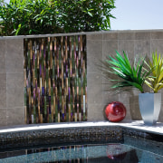 Glaas tiles were laid horizontally to create an arecales, palm tree, plant, property, swimming pool, wall, water, water feature, gray