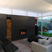 A second living area, which doubles as a fireplace, hearth, interior design, living room, wood burning stove, black, white