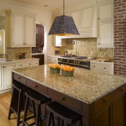 The kitchen is laid open to adjoining rooms.Beyond cabinetry, countertop, cuisine classique, floor, flooring, hardwood, home, interior design, kitchen, room, tile, wood flooring, brown, orange