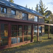 An exterior view of this lakeside house featuring cottage, facade, home, house, property, real estate, window, black