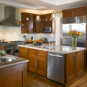 The open-plan kitchen has two islands to increase cabinetry, countertop, cuisine classique, hardwood, interior design, kitchen, room, brown, gray