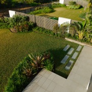 A view of these landscaped gardens and pool arecales, backyard, courtyard, estate, garden, grass, grass family, house, landscape, landscaping, lawn, plant, property, real estate, walkway, yard, brown