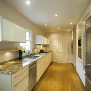 A view of this minimalist clean lined kitchen cabinetry, ceiling, countertop, cuisine classique, interior design, kitchen, real estate, room, brown, orange