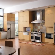 A view of this kitchen featuring the latest cabinetry, countertop, cuisine classique, floor, flooring, hardwood, home appliance, interior design, kitchen, living room, room, wood flooring, brown, gray