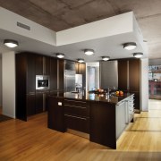 A view of an apartment complex developed by cabinetry, ceiling, countertop, floor, flooring, hardwood, interior design, kitchen, laminate flooring, wood flooring, gray