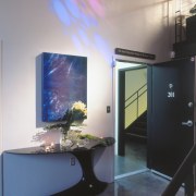 A view of the entrance way, concrete flooring, display device, glass, interior design, table, gray, black