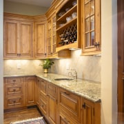 A view of this kitchen featuring Plato Woodwork cabinetry, countertop, cuisine classique, flooring, furniture, hardwood, home, interior design, kitchen, room, under cabinet lighting, wall, wood stain, brown, orange
