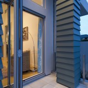 Large bifold doors lead from the open-plan living architecture, facade, home, structure, blue, gray