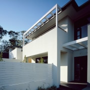 An exterior view of this house featuring coastal architecture, building, daylighting, elevation, estate, facade, home, house, property, real estate, residential area, roof, siding, sky, window, teal