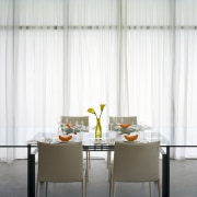 An interior view of this contemporary living area chair, curtain, decor, dining room, furniture, interior design, room, table, window covering, window treatment, white