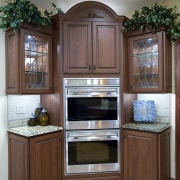 A view of this remodelled kitchen designed by cabinetry, countertop, cuisine classique, furniture, hardwood, home appliance, kitchen, kitchen appliance, room, wood stain, gray, brown