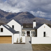 The building code at a resort prescribes the architecture, cottage, elevation, estate, facade, farmhouse, home, house, mountain, property, real estate, residential area, roof, siding, sky, snow, window, winter, gray