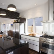 View of kitchen and living area designed by countertop, interior design, kitchen, real estate, gray, black