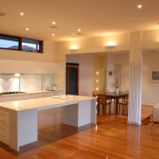 An interior view of the kitchen featuring stained ceiling, floor, flooring, hardwood, interior design, kitchen, lighting, property, real estate, room, table, wood flooring, brown, orange