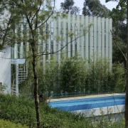 Exterior view of a house in the environmentally architecture, fence, house, outdoor structure, property, real estate, tree, gray