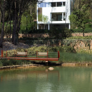 Exterior view of a house in the environmentally bank, body of water, cottage, home, house, lake, plant, pond, real estate, reflection, river, sky, tree, water, waterway, brown