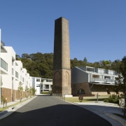 The towering brick chimney is one of the architecture, building, condominium, corporate headquarters, house, mixed use, neighbourhood, property, real estate, residential area, sky, teal