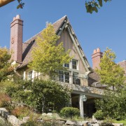 View of exterior of house, clay tile roof, building, cottage, estate, facade, home, house, mansion, plant, property, real estate, sky, tree, villa, brown, teal