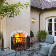 View of patio, outdoor furniture, fireplace, Plaster walls, backyard, courtyard, fireplace, hearth, home, house, interior design, living room, outdoor structure, patio, real estate, wood burning stove, gray