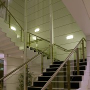 A view of this feature stair case where architecture, ceiling, daylighting, glass, handrail, interior design, stairs, structure, brown