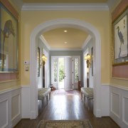 The hallway in this remodeled house is divided ceiling, column, daylighting, estate, floor, flooring, hall, hardwood, home, interior design, laminate flooring, living room, lobby, molding, property, real estate, room, wall, window, wood flooring, brown, gray